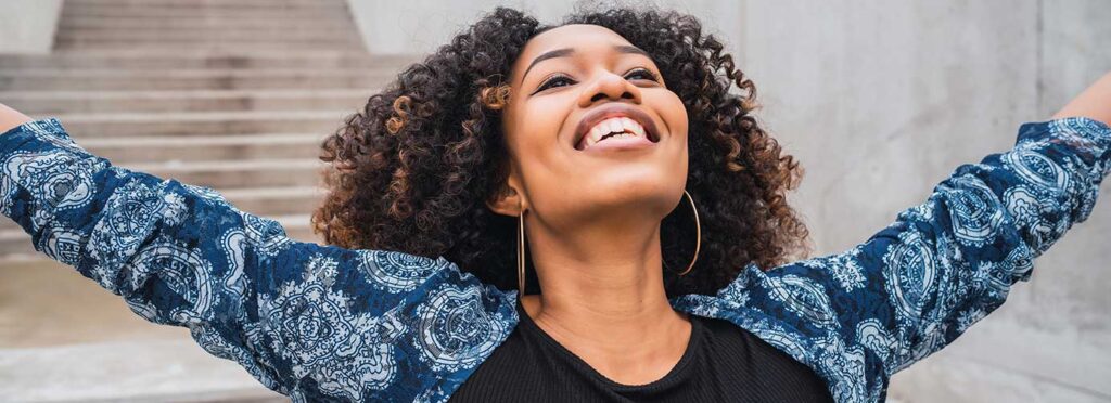 InMind Behavioral Health Embracing Change, woman smiling with her head back smiling and arms open to the sky